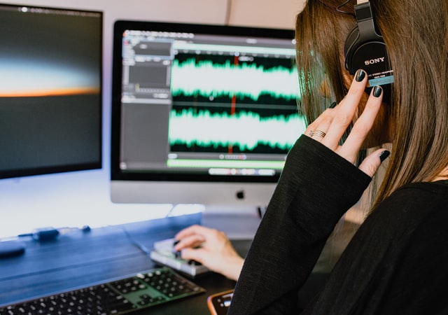 woman editing audio file on computer