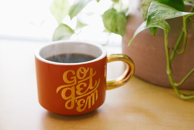 go get em design on orange coffee cup with hold handle