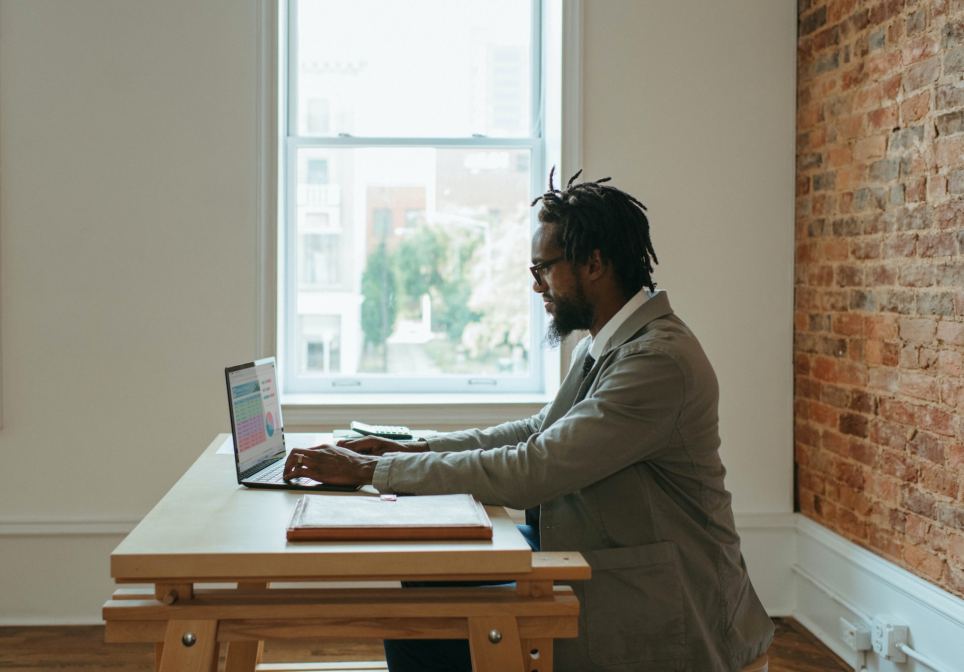 A business man sitting at a desk, working on a laptop