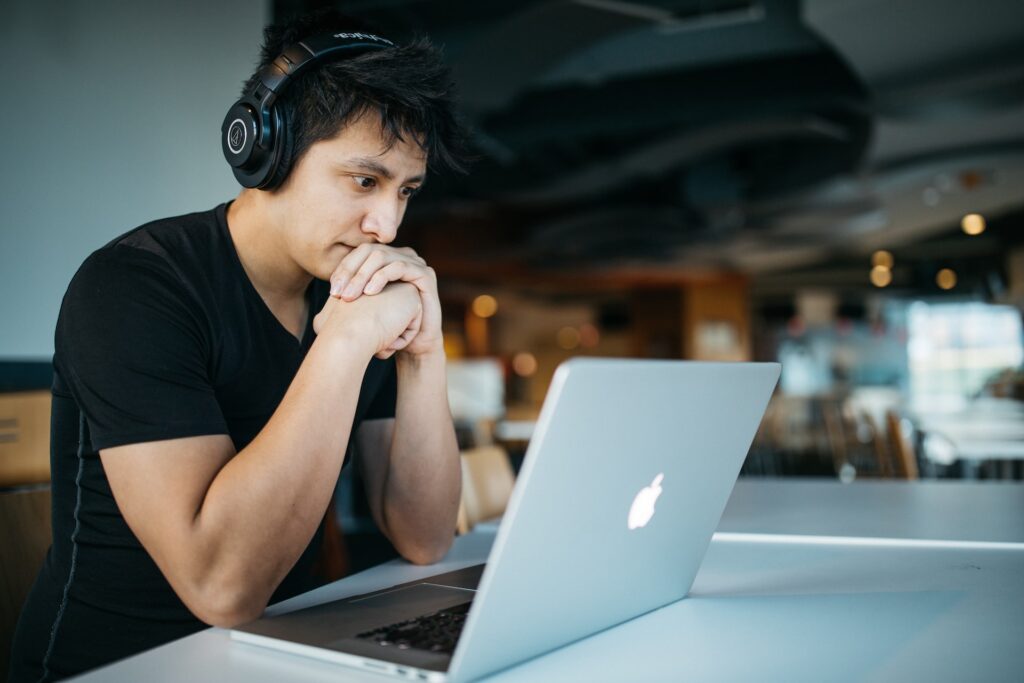 A man staring intently at his computer while experiencing flexible work guilt
